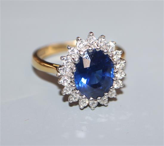 A modern 18ct gold, sapphire and diamond set oval cluster ring, size O.
